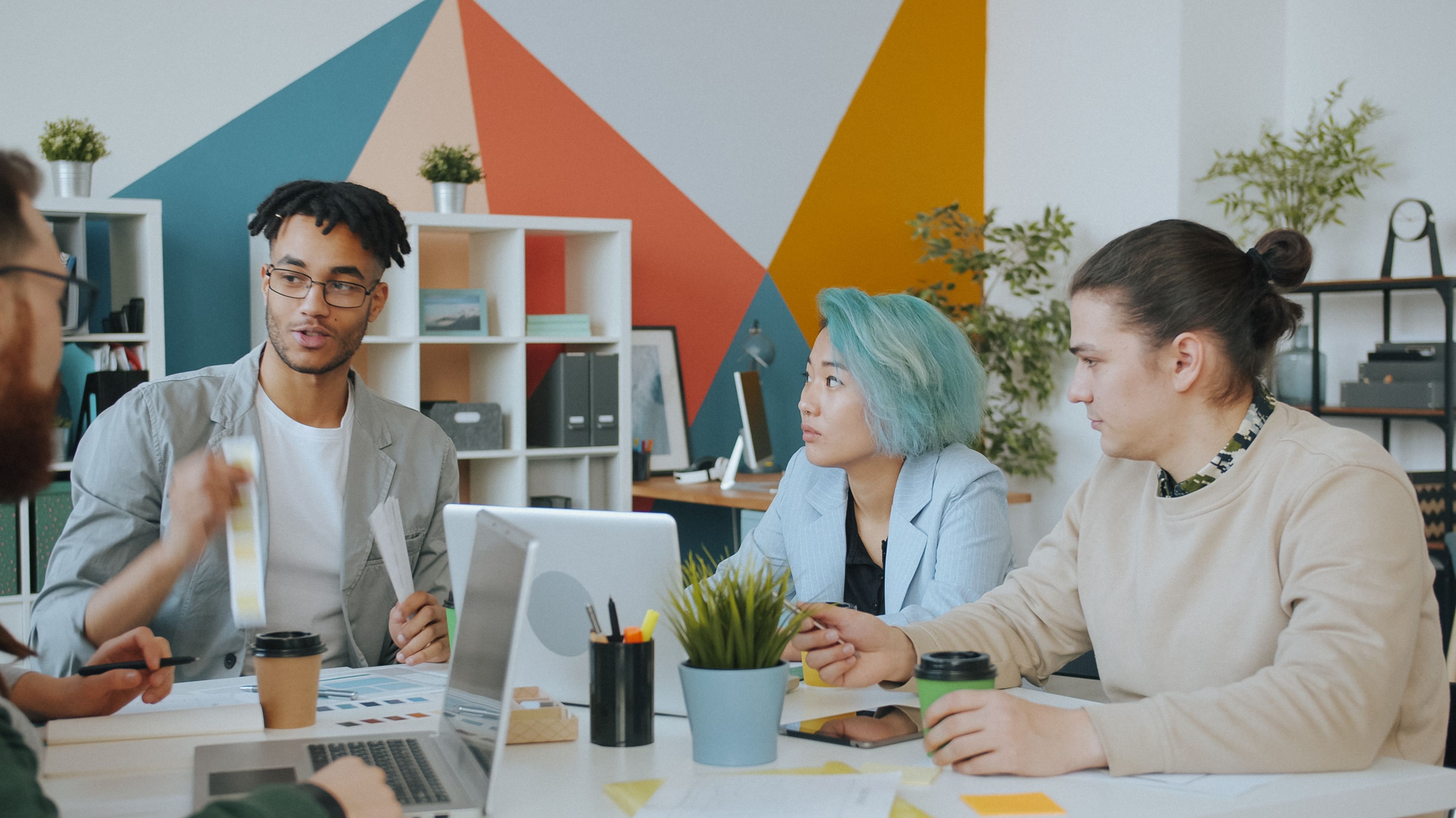 Profesionales compartiendo ideas alrededor de una mesa, fotografía ilustrativa.